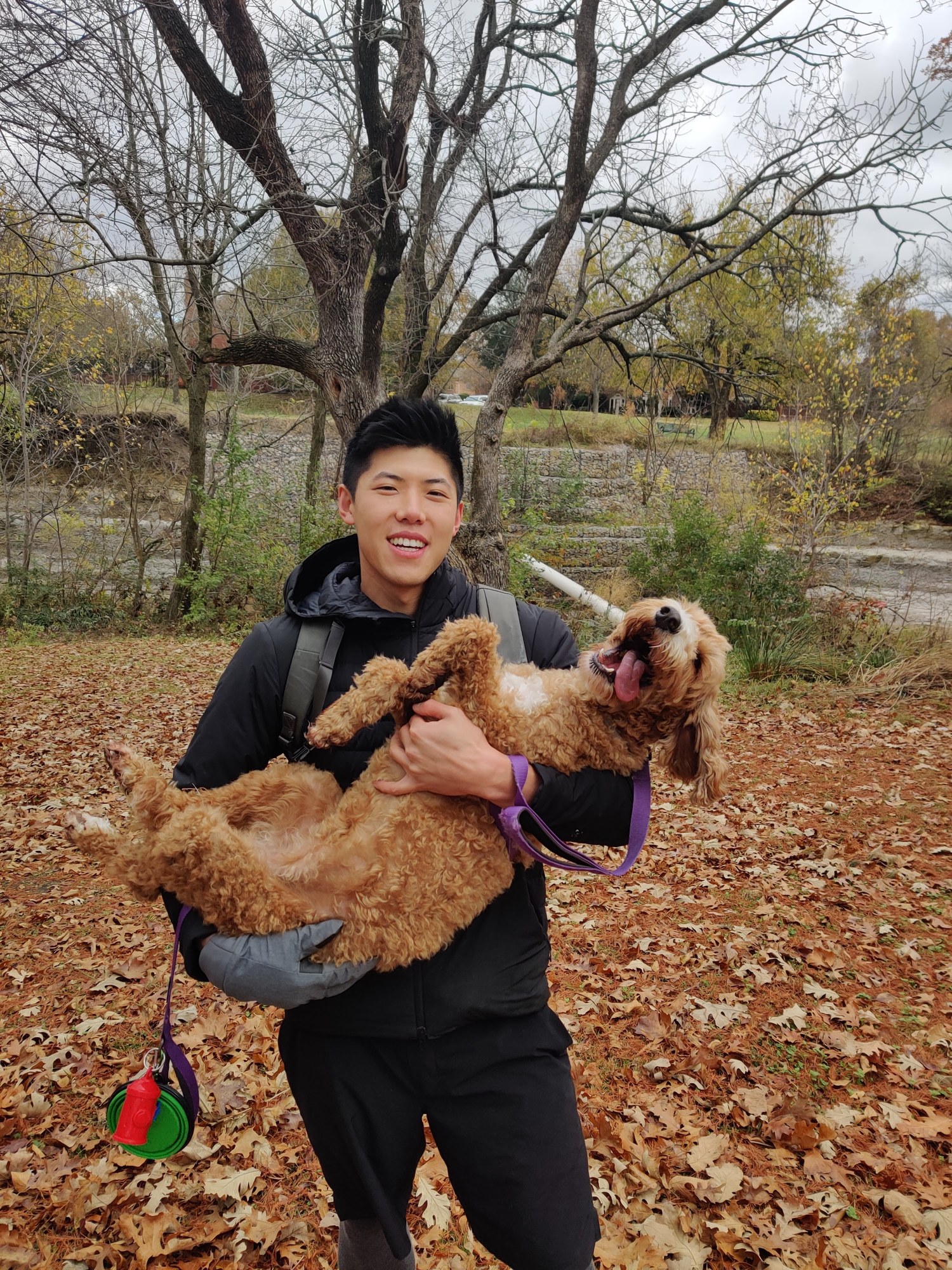 Justin holding Peanut belly-up during an autumn walk.